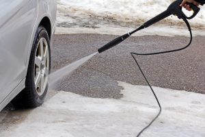 Car wash in winter - a man washes his car