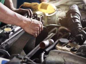 Hands of car mechanic holding the fan of Radiator in garage. Car repair