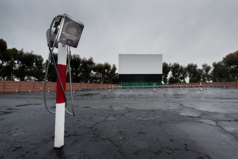 Parking area for a drive in movie with screen and speaker poles