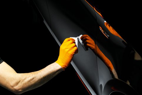 Car polish wax worker hands polishing car. Buffing and polishing vehicle with ceramic. Car detailing. Man holds a polisher in the hand and polishes the car with nano ceramic. Tools for polishing