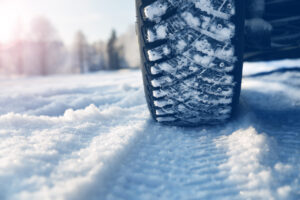 Closeup of car tires in winter on the road covered with snow.