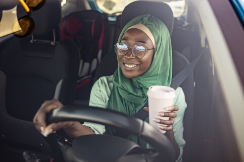 Teenager drinking coffee while driving