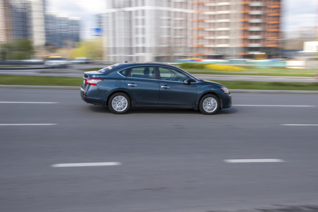 Blue Nissan Sentra car moving on the street.