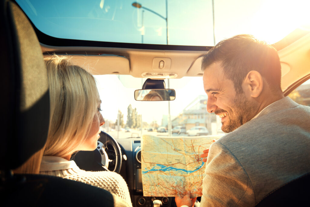 Couple traveling looking at map on a road trip 