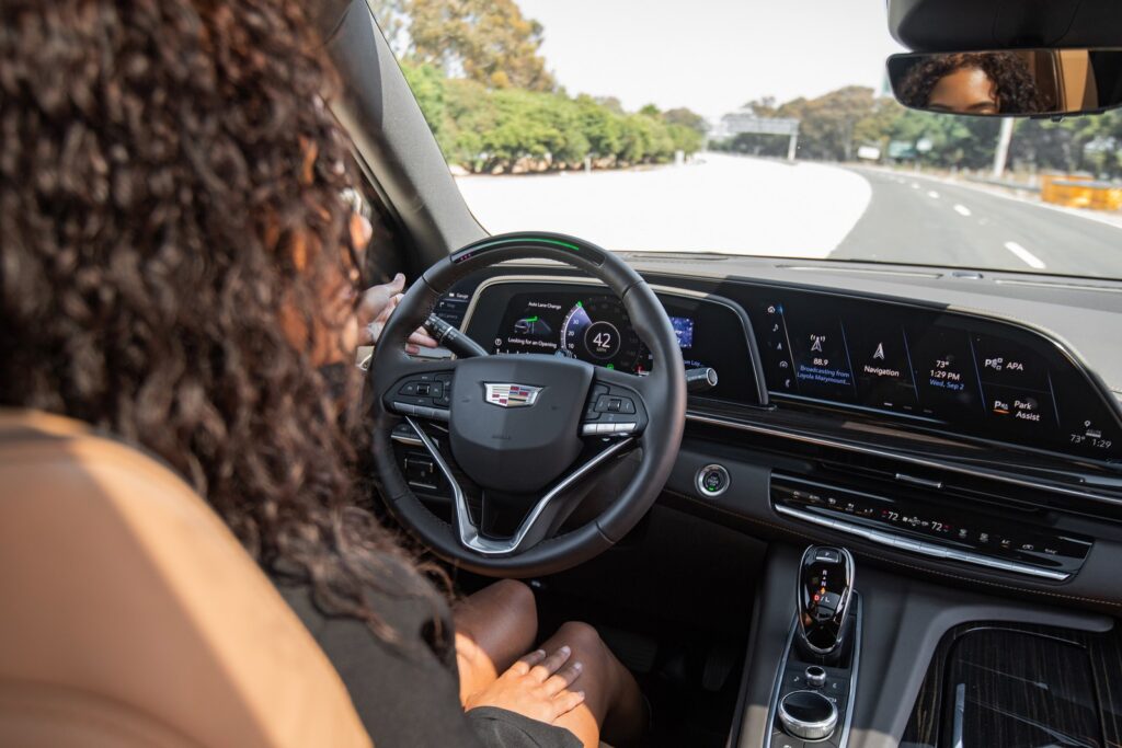 Over the shoulder shot of a woman using Super Cruise, the industry’s first true hands-free driver assistance technology, in a Cadillac Escalade