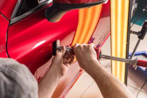 The technician removes dents on the car using the method without painting.